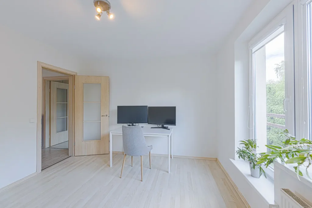 Minimalistinis darbo kambarys su dviem monitoriais ir šviesiomis grindimis